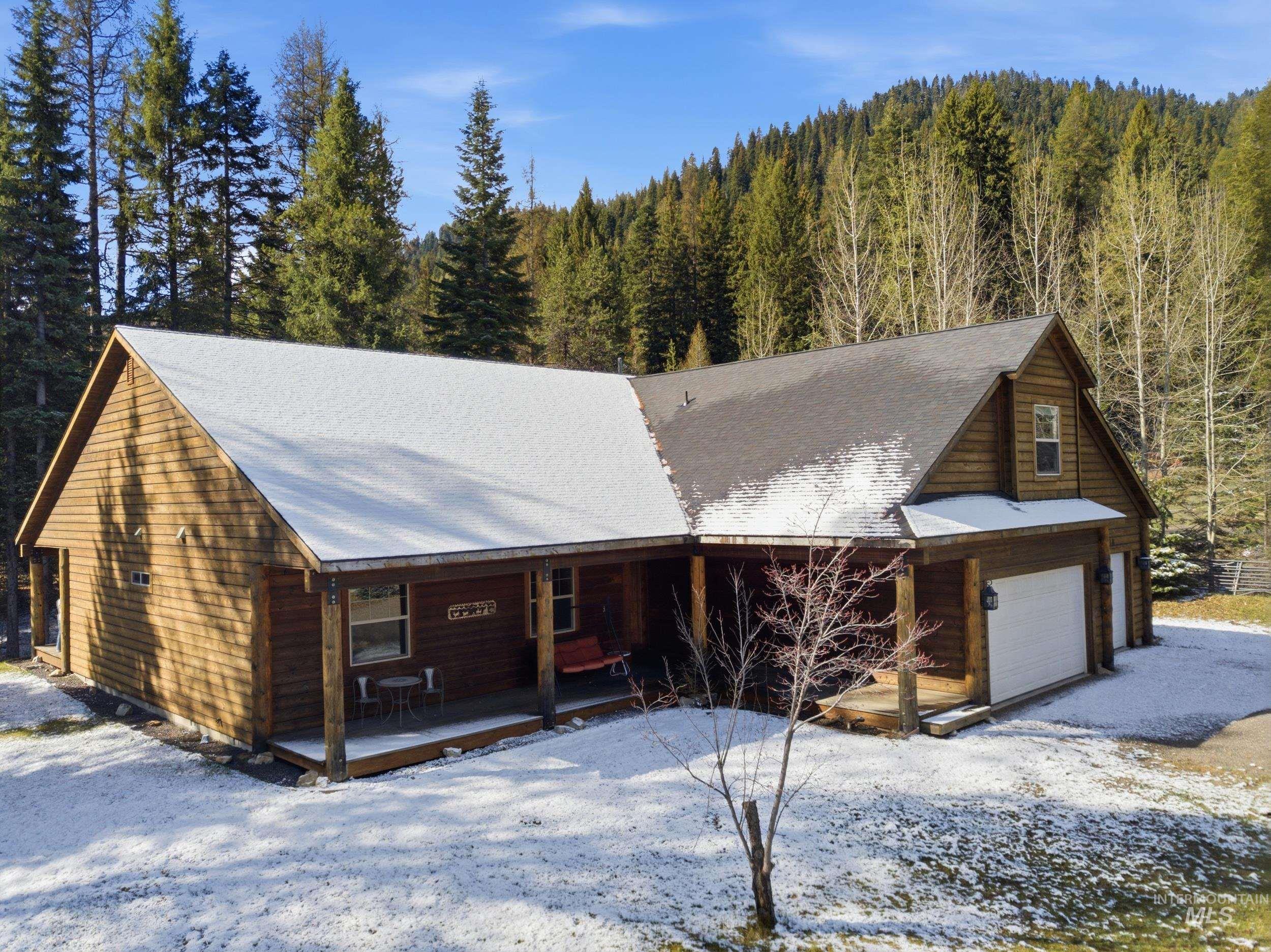 2538 West Mountain Road Donnelly, ID 83615 - Photo 5 of 50 Wood-sided residence featuring a covered front porch, an attached garage with two bays, and a dormer window