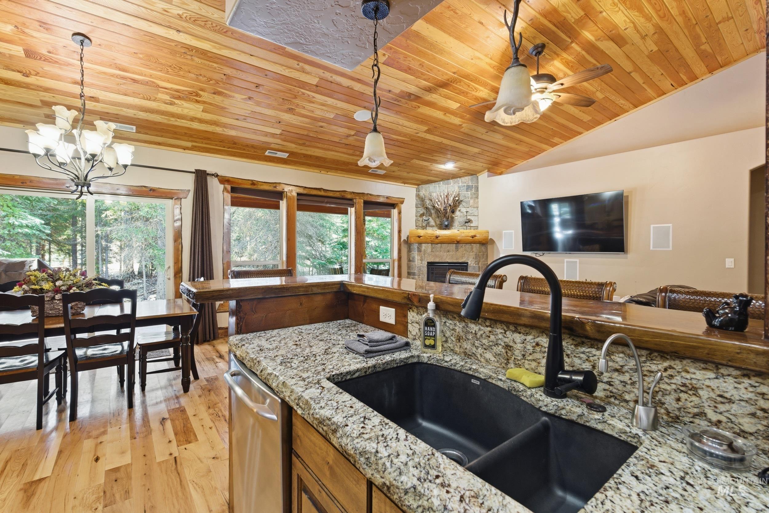 2538 West Mountain Road Donnelly, ID 83615 - Photo 8 of 50 Gourmet kitchen featuring granite countertops, a black double basin sink with a matte black gooseneck faucet, and integrated stainless steel dishwasher