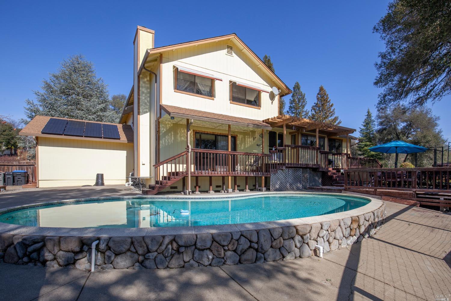 a front view of a house with swimming pool and sitting area