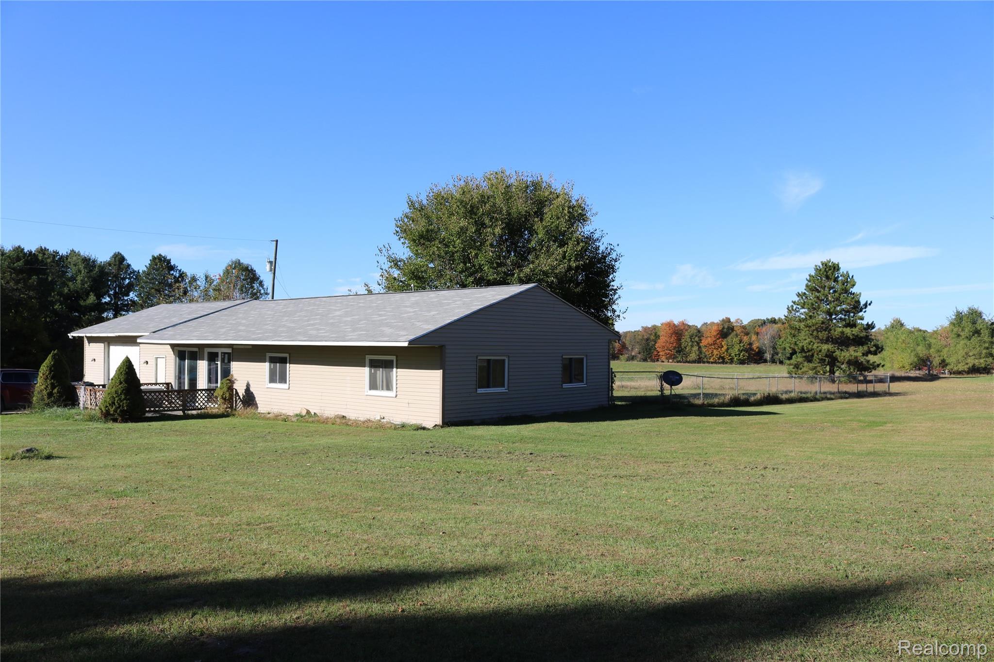 View of side of home with a yard and a deck