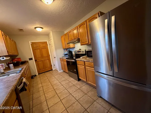 a kitchen with stainless steel appliances a refrigerator sink and cabinets