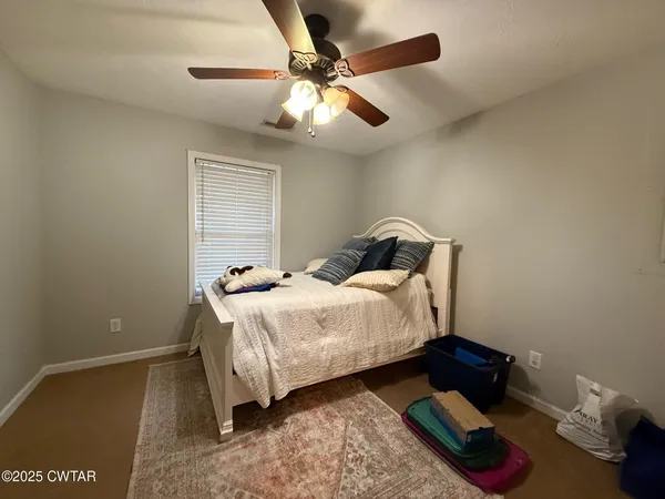 a bedroom with a bed and a ceiling fan