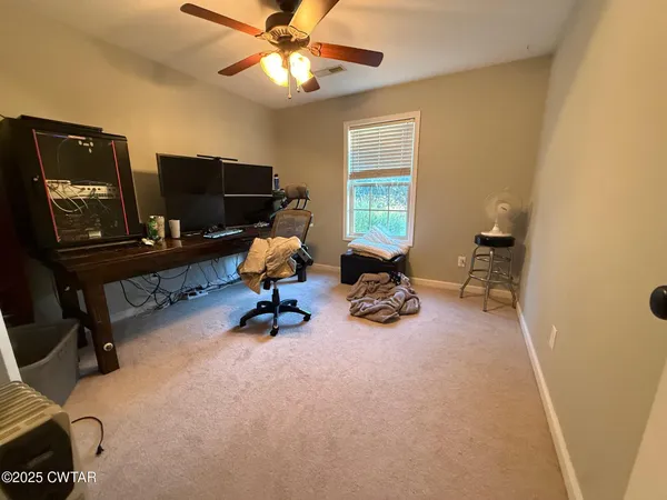 a view of a workspace with furniture and a window