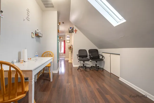a kitchen with stainless steel appliances kitchen island granite countertop a table chairs sink and cabinets