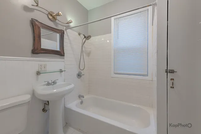 a bathroom with a sink a mirror toilet and bathtub
