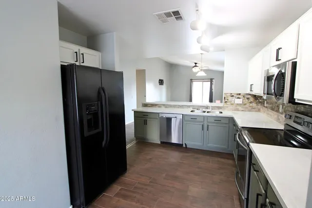 a kitchen with stainless steel appliances a refrigerator sink and stove
