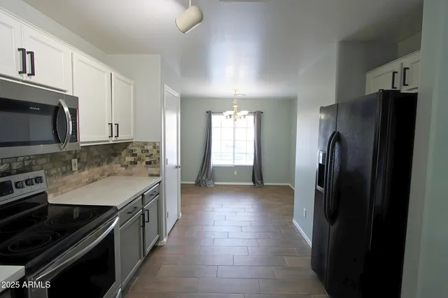 a kitchen with stainless steel appliances granite countertop a refrigerator and a stove top oven