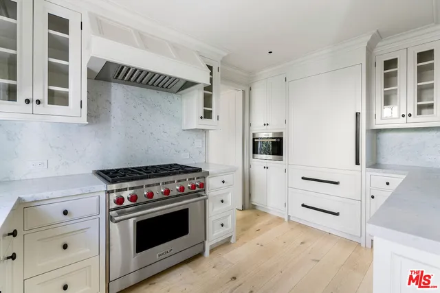 a kitchen with cabinets appliances and a wooden floor
