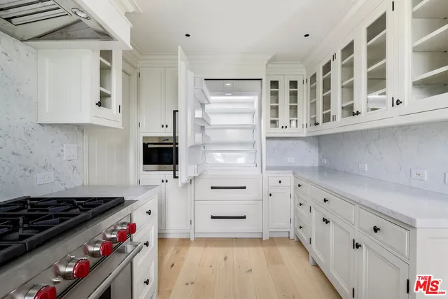a kitchen with white cabinets and appliances