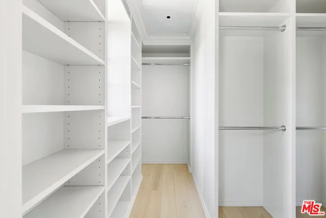 a view of walk in closet with empty racks