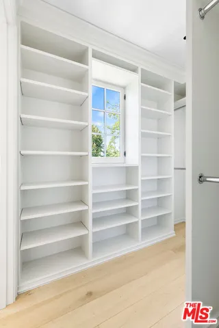 a view of walk in closet with empty racks