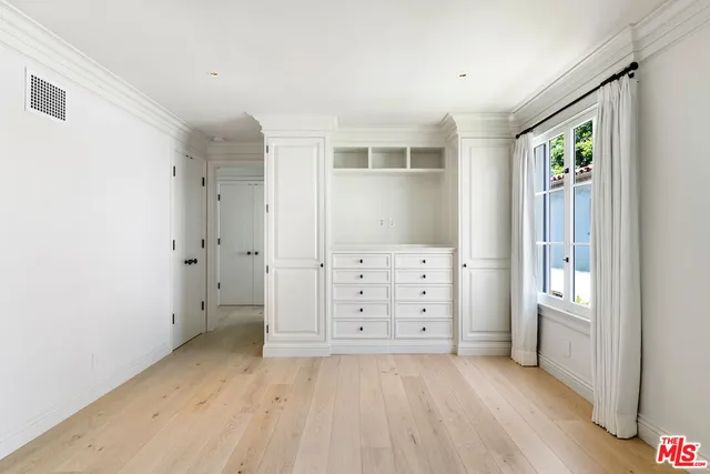 an empty room with windows and cabinet