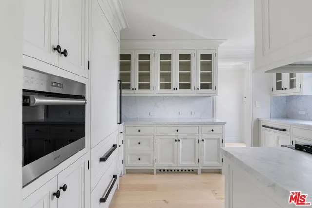 a kitchen with white cabinets and a fireplace
