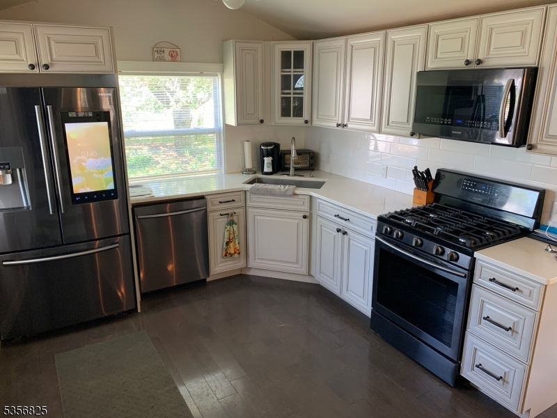 7 Shore Road Wayne, NJ 07470 - Photo 6 of 13 a kitchen with stainless steel appliances a stove a sink and a window