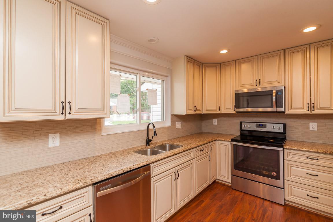 6009 Backlick Road Springfield, VA 22150 - Photo 3 of 21 a kitchen with granite countertop a sink cabinets stainless steel appliances and a window