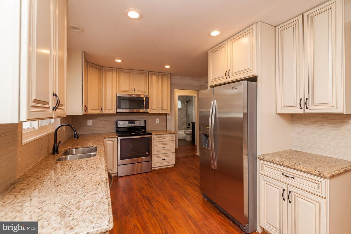 6009 Backlick Road Springfield, VA 22150 - Photo 4 of 21 a kitchen with granite countertop a refrigerator stove and sink