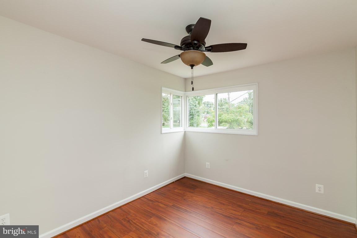 6009 Backlick Road Springfield, VA 22150 - Photo 8 of 21 an empty room with wooden floor fan and windows