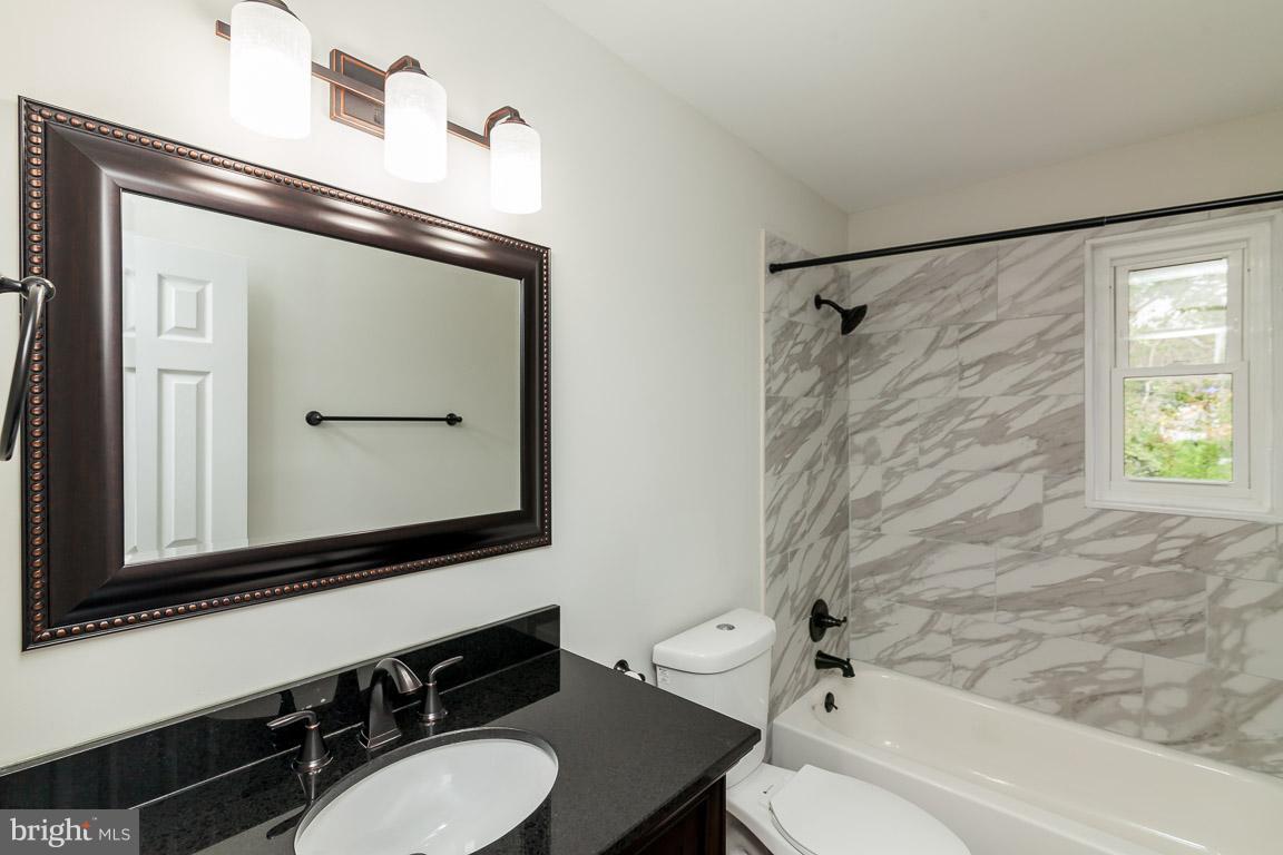 6009 Backlick Road Springfield, VA 22150 - Photo 9 of 21 a bathroom with a sink a toilet a mirror and shower
