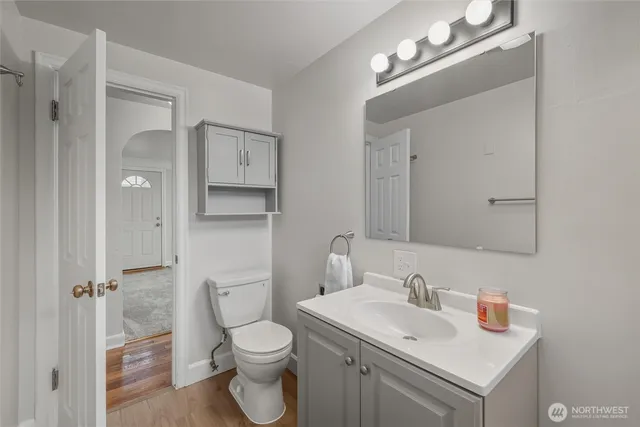 a bathroom with a toilet sink vanity and mirror