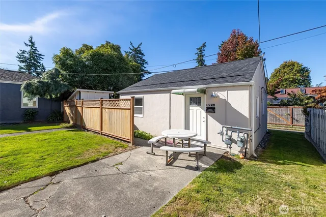a backyard of a house with table and chairs