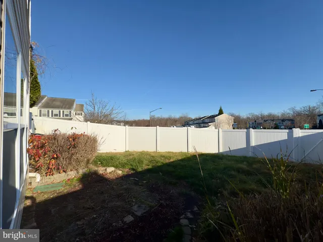 a view of a hallway with wooden floor and a bathroom