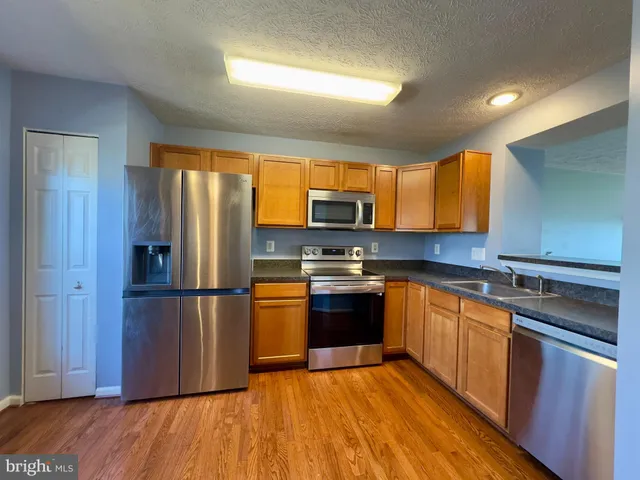 a kitchen with stainless steel appliances a refrigerator and a stove top oven