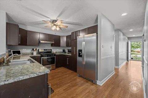a kitchen with stainless steel appliances granite countertop a sink stove and refrigerator