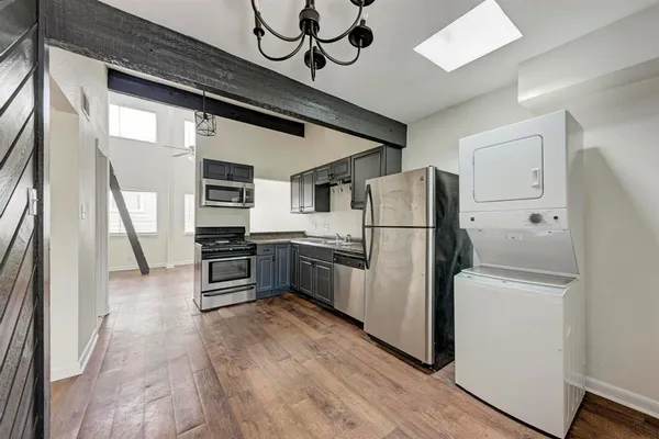 a kitchen with stainless steel appliances a refrigerator and a stove top oven