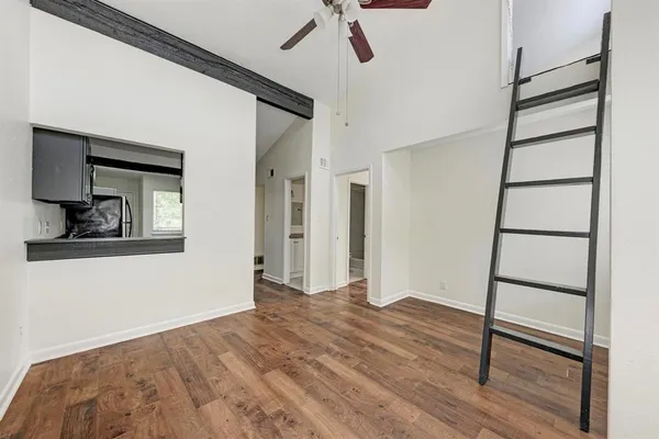 a view of an empty room with wooden floor