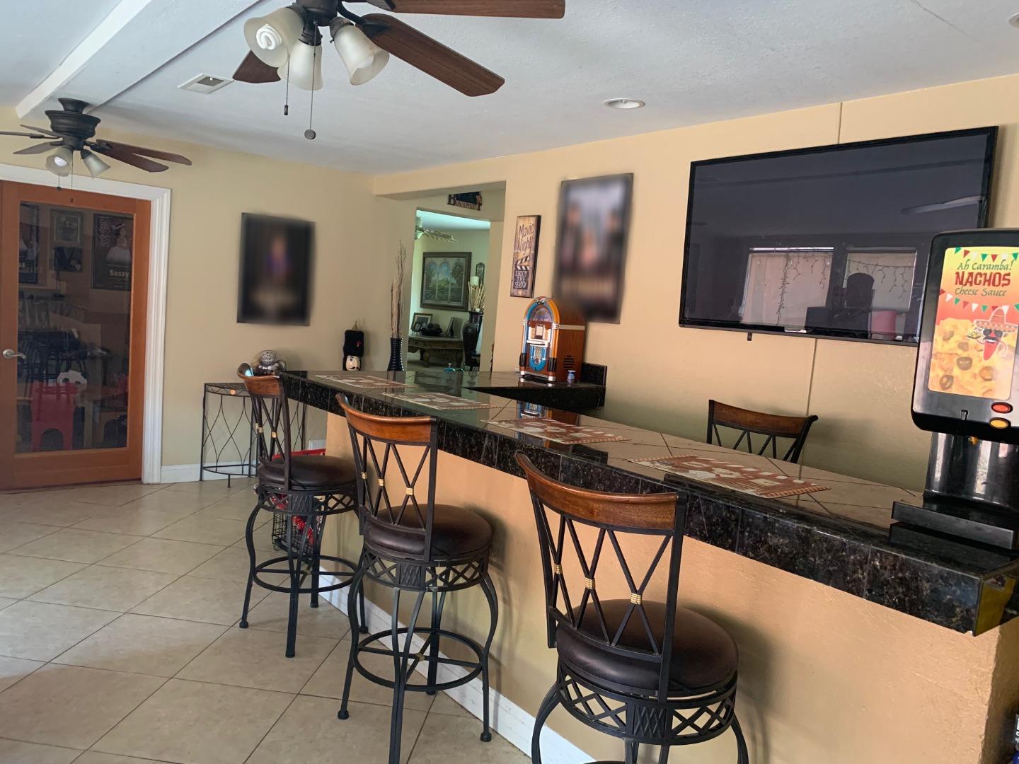 461 Soledad Street Soledad, CA 93960 - Photo 18 of 21 a room with stainless steel appliances kitchen island granite countertop a table chairs in it and wooden floor