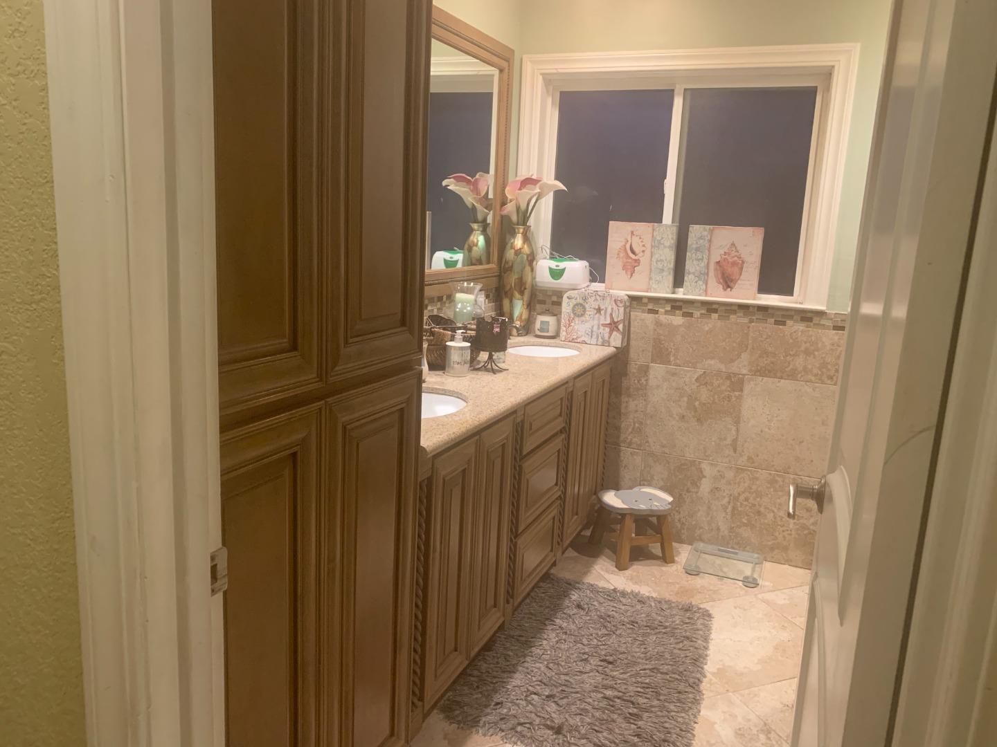 461 Soledad Street Soledad, CA 93960 - Photo 9 of 21 a bathroom with a granite countertop sink a toilet and a mirror