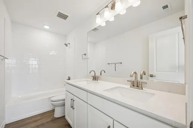 a bathroom with a sink a toilet and a large mirror