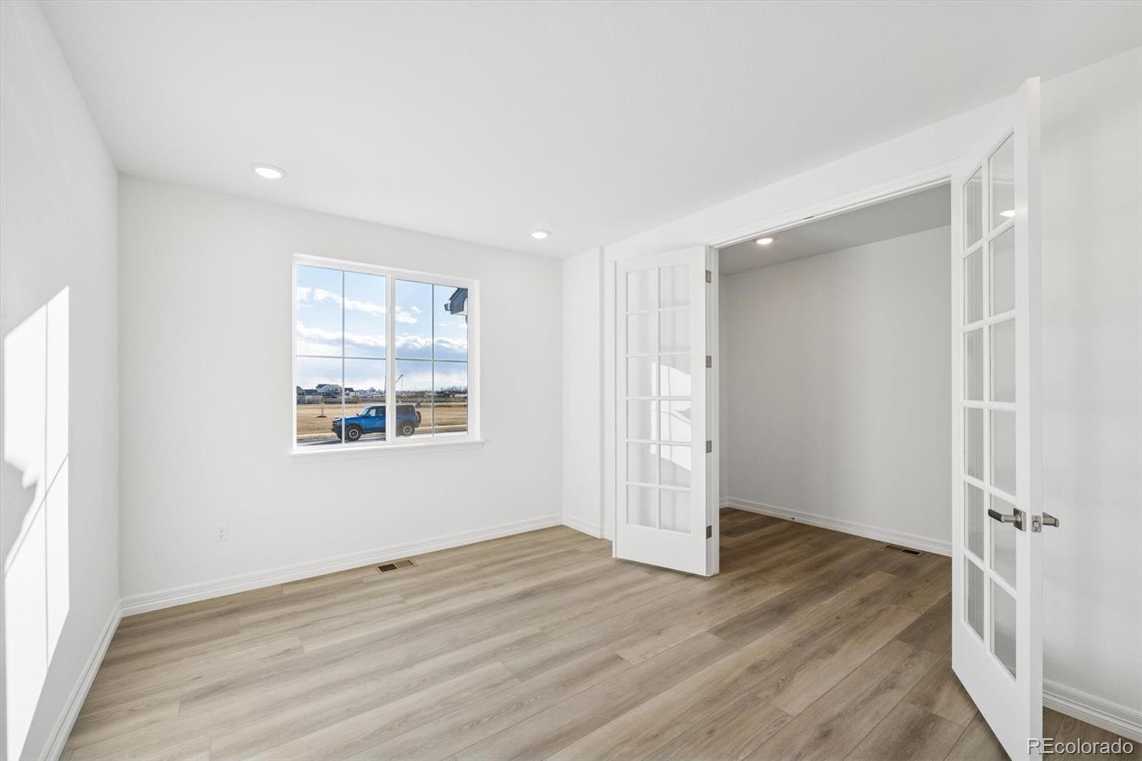 6120 Oban Road Timnath, CO 80547 - Photo 2 of 22 an empty room with wooden floor and windows