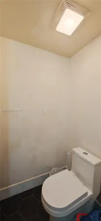 a white toilet sitting next to a white cabinet