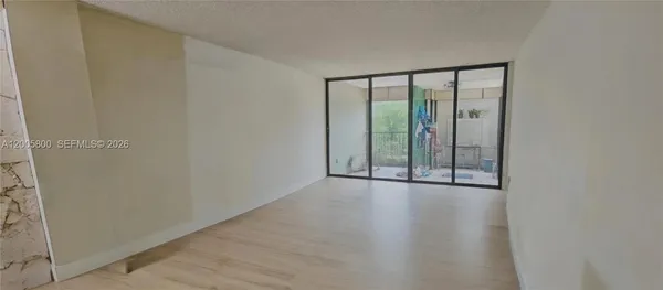 a view of a room with wooden floor and windows