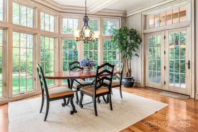 a dining room with furniture large windows and wooden floor