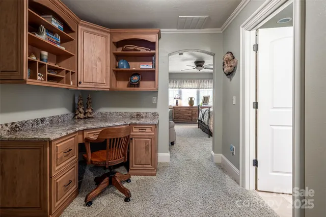 a bedroom with a bed a ceiling fan and a large window