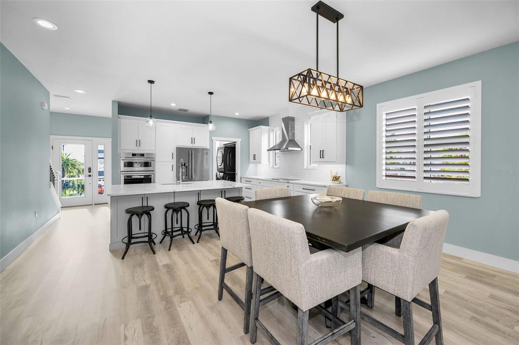 5650 Egrets Place New Port Richey, FL 34652 - Photo 20 of 73 a dining room with wooden floor a chandelier a wooden table and chairs