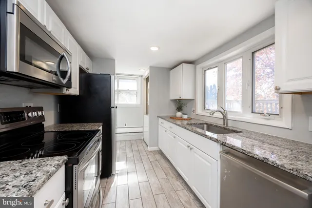 a kitchen with a sink stove top oven and cabinets
