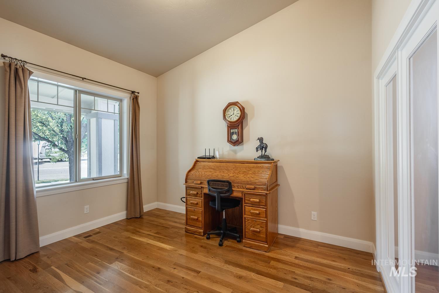 1186 East Observation Street Meridian, ID 83642 - Photo 18 of 33 Room featuring wood-finish flooring, a large window with transom details, neutral wall tones, and white trim
