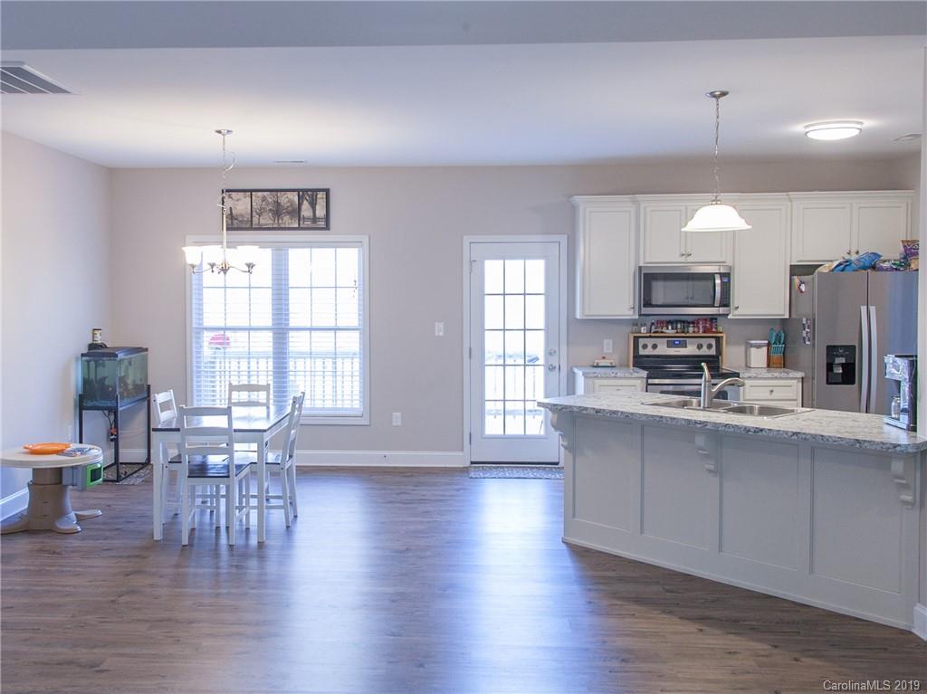 3018 Ranger Road, Unit 2B Clover, SC 29710 - Photo 7 of 23 a kitchen with stainless steel appliances granite countertop a stove top oven a sink a dining table and chairs