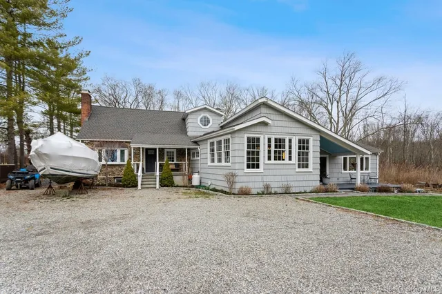 a front view of a house with a garden and trees
