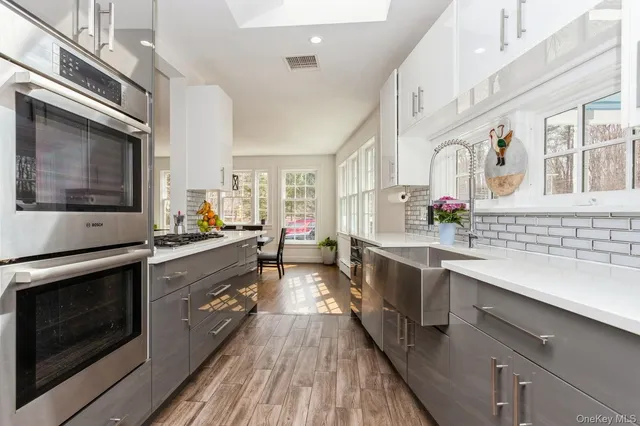 a kitchen with stainless steel appliances sink a stove and cabinets