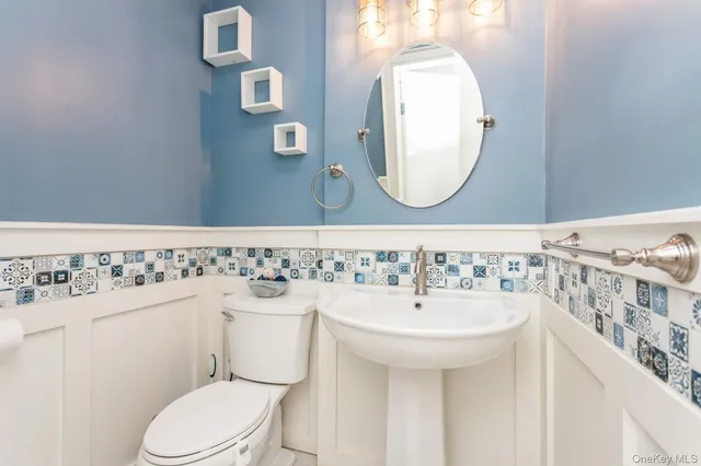 a bathroom with a sink mirror and toilet