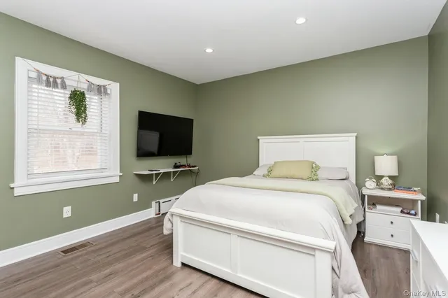 a bedroom with a bed and a flat screen tv