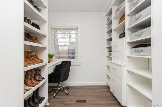 a view of a workspace with furniture and a window
