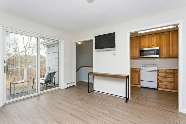 a living room with stainless steel appliances furniture and a flat screen tv