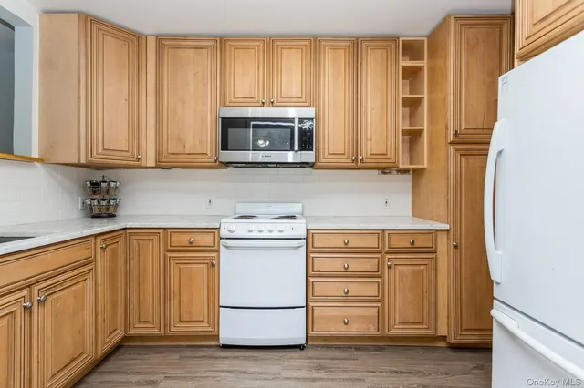 a kitchen with granite countertop white cabinets and stainless steel appliances
