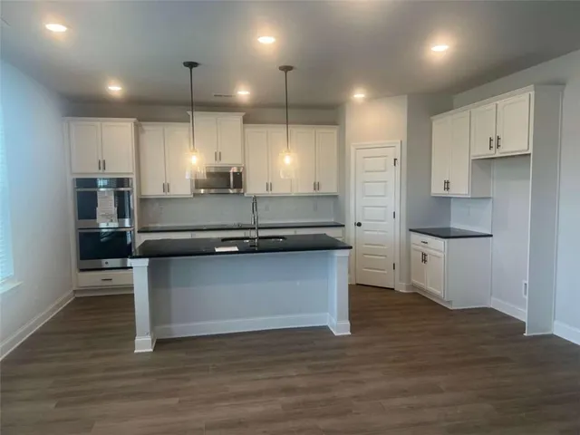 a kitchen with kitchen island a sink appliances and cabinets