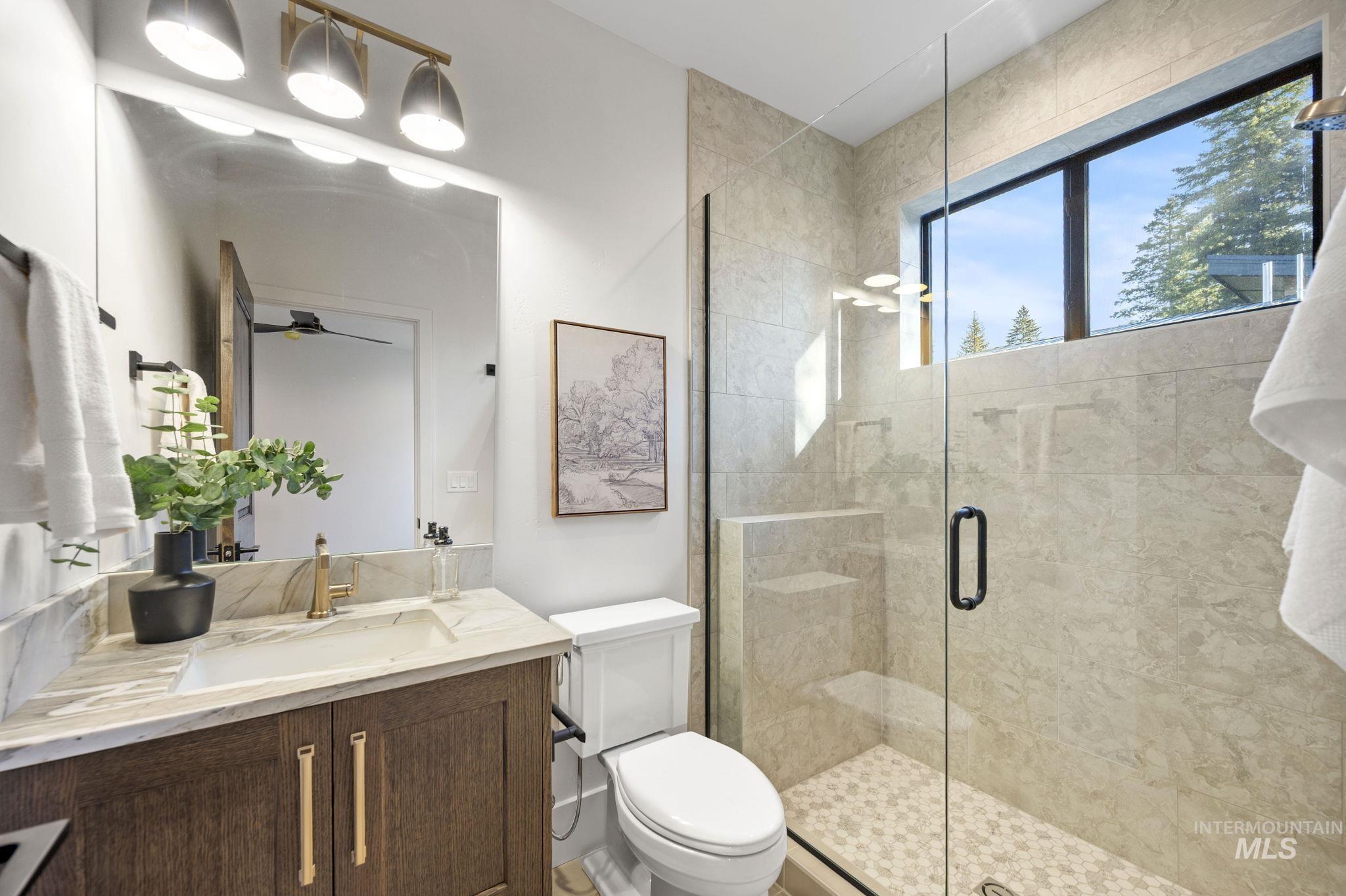 1008 Violet Way McCall, ID 83638 - Photo 10 of 37 Bathroom featuring a stall shower, vanity, and ceiling fan